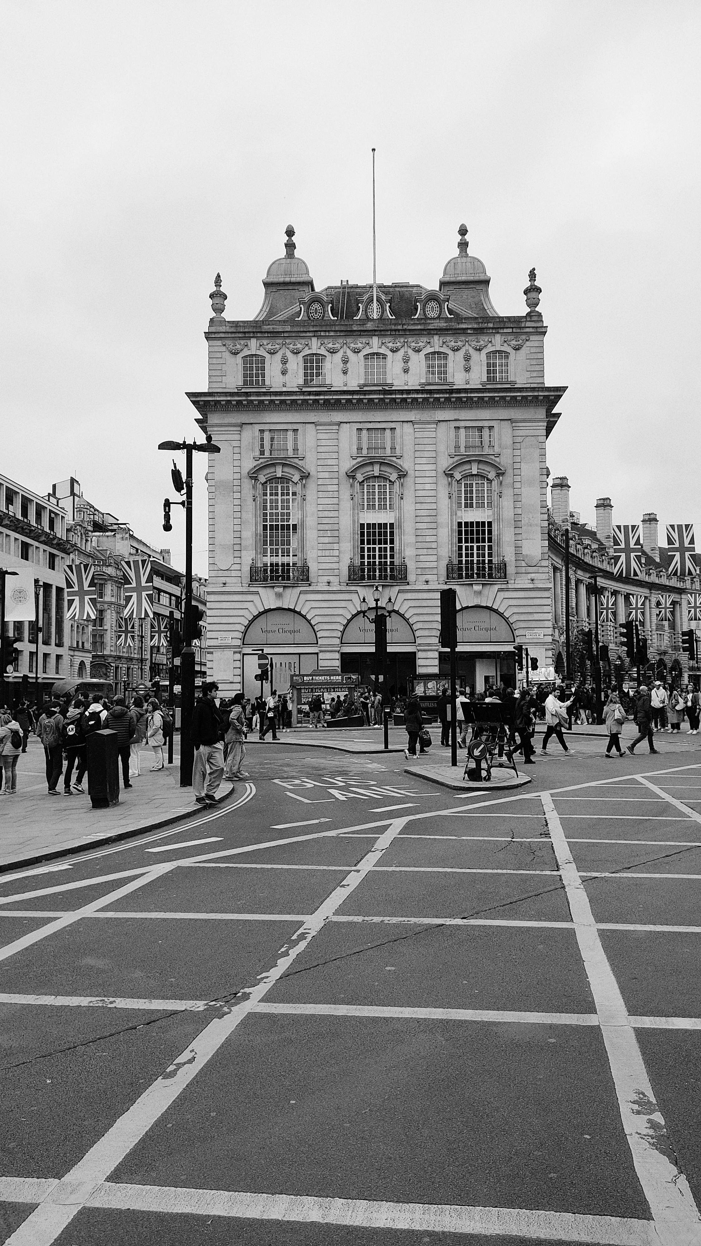 Black and white photo of a bustling London street with classic architecture.