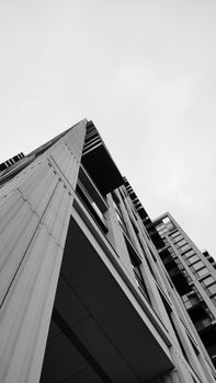 Dynamic low angle shot of a modern skyscraper in black and white, emphasizing architecture.