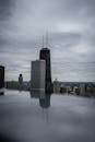 阴天的汉考克大厦倒映在水中，映衬着喜怒无常的芝加哥天际线
