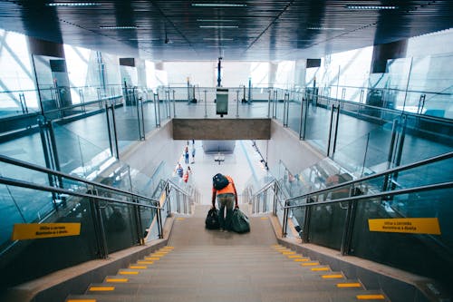 Hombre De Pie En La Escalera Sosteniendo Dos Bolsas