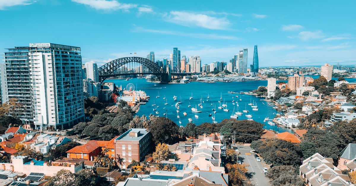Stunning aerial view of Sydney's iconic skyline and harbor, featuring the famous Sydney Harbour Bridge.