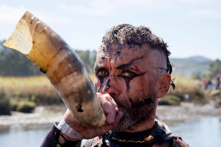 Man With A Painted Face Blowing A Horn 