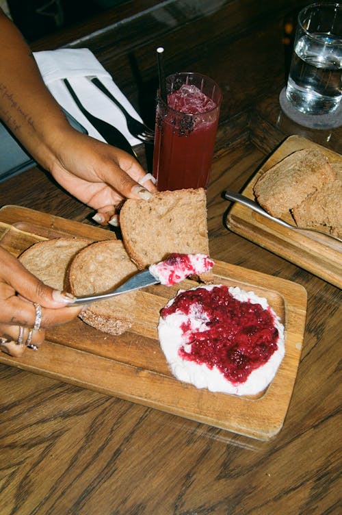 Woman Hand Putting Cottage Cheese with Jam on Bread