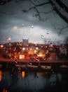 黄昏时，窗户上的雨滴模糊了城市景观，也捕捉到了城市的灯光