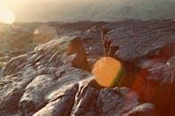 特写镜头捕捉了岩石地形，阳光与散景营造出戏剧性效果