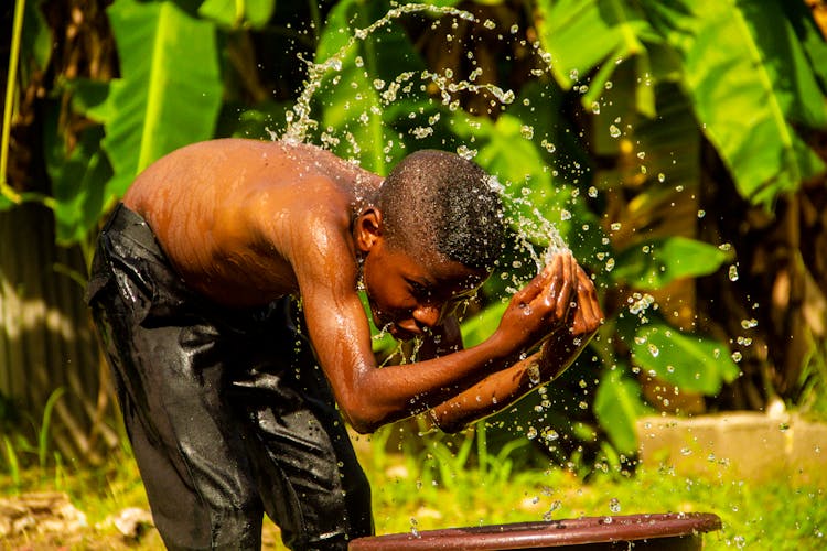 Little Boy Washing In Nature