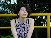 穿着雏菊图案衣服的年轻女子若有所思地反对着某种性质