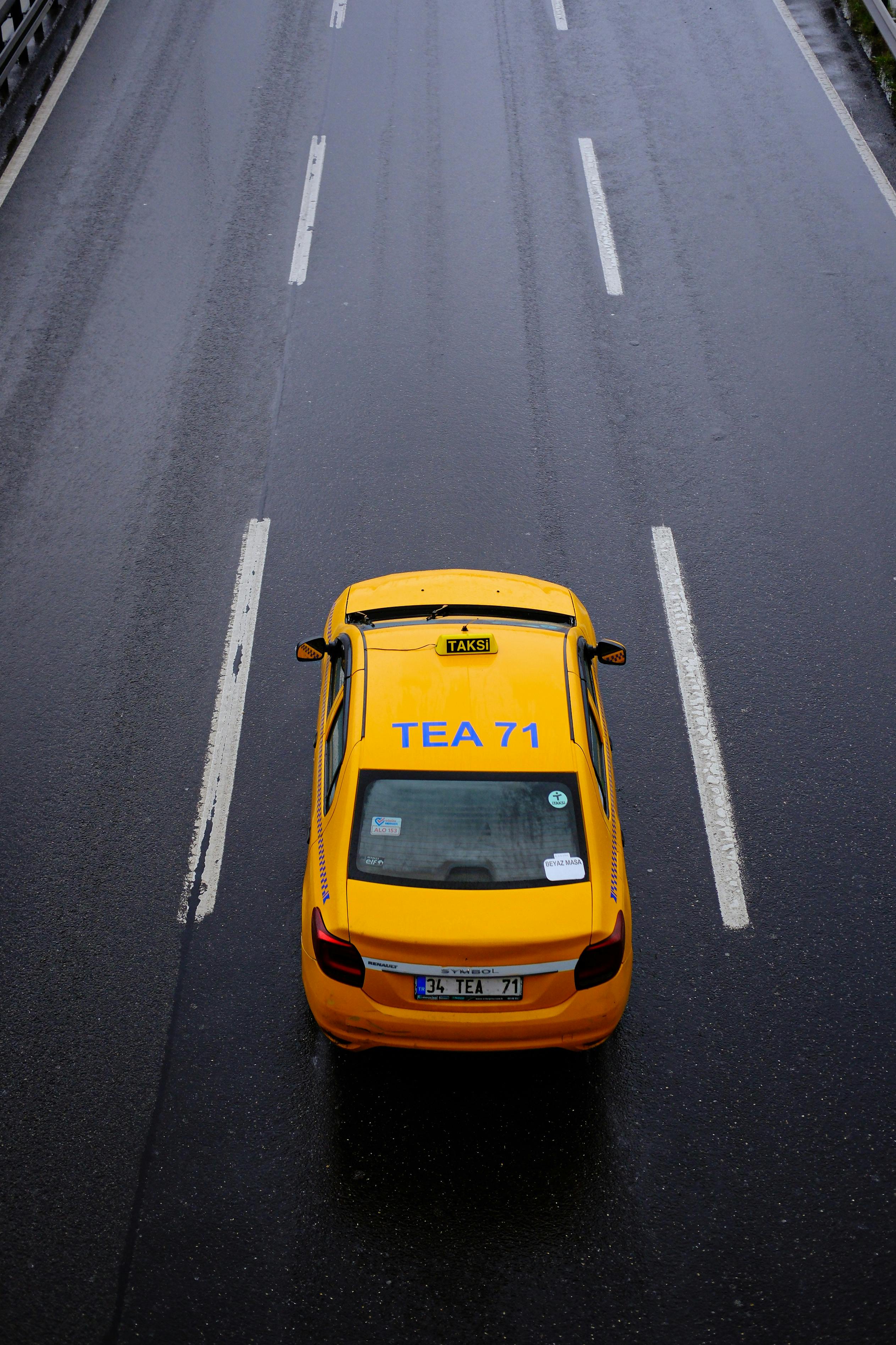 a taxi cab is seen on a wet road