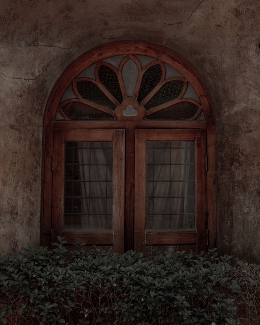 Charming wooden window with decorative arch in Kochi, India. Perfect for architectural and travel themes.