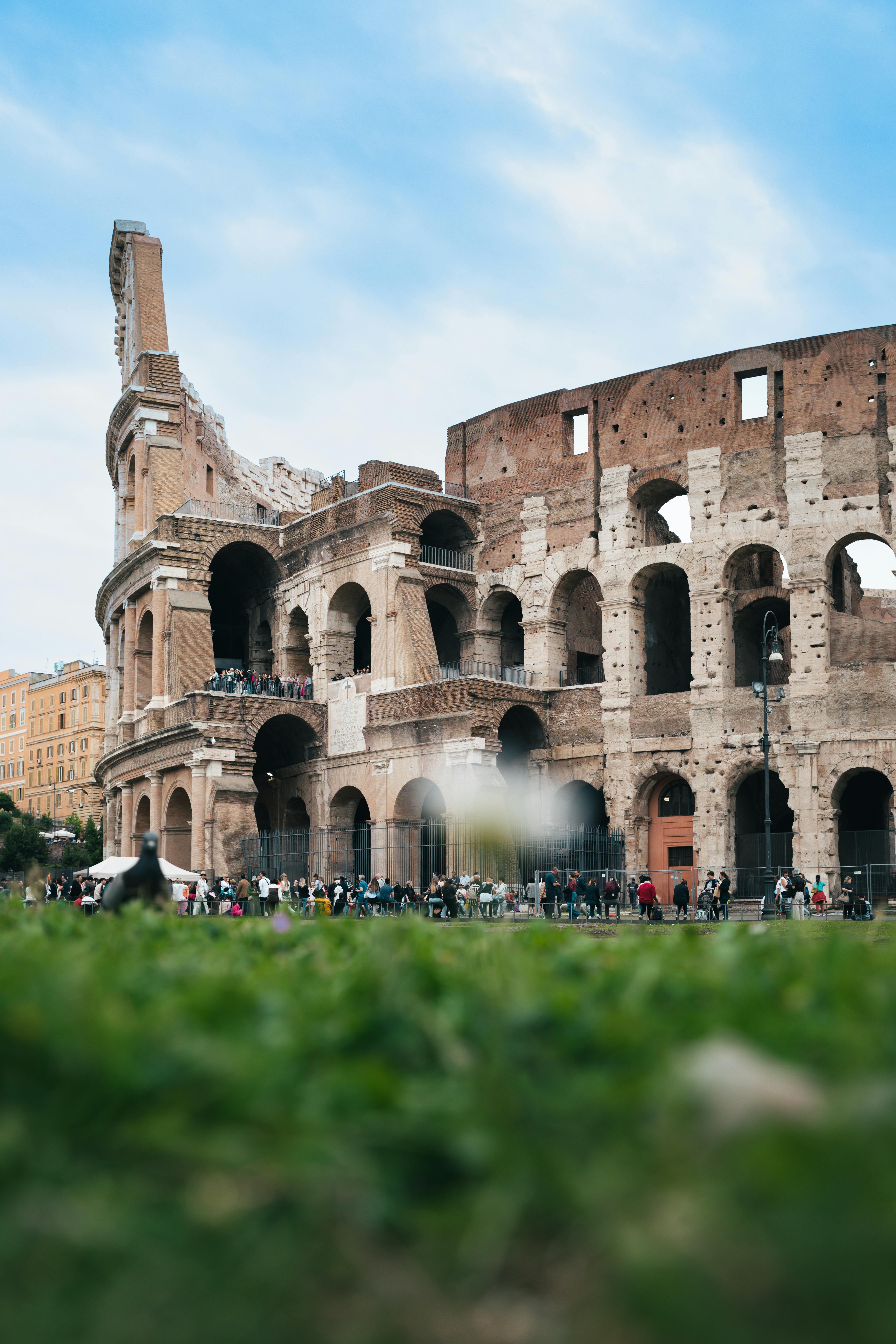 Capture of the iconic Colosseum in Rome with vibrant skies and historic architecture.
