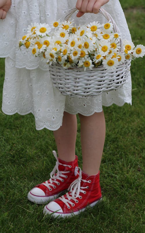 Woman in a White Dress and Red Shoes Holding a Basket of Flowers 
