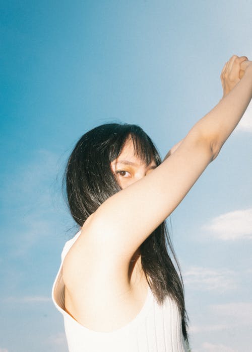 Brunette Practising Yoga against Sky