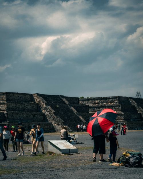 Free Tourists walking near ancient pyramids in Teotihuacan, Mexico, on a cloudy day. Stock Photo