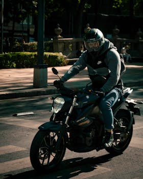 Man riding a motorcycle in urban Mexico City, showcasing city life and transportation.