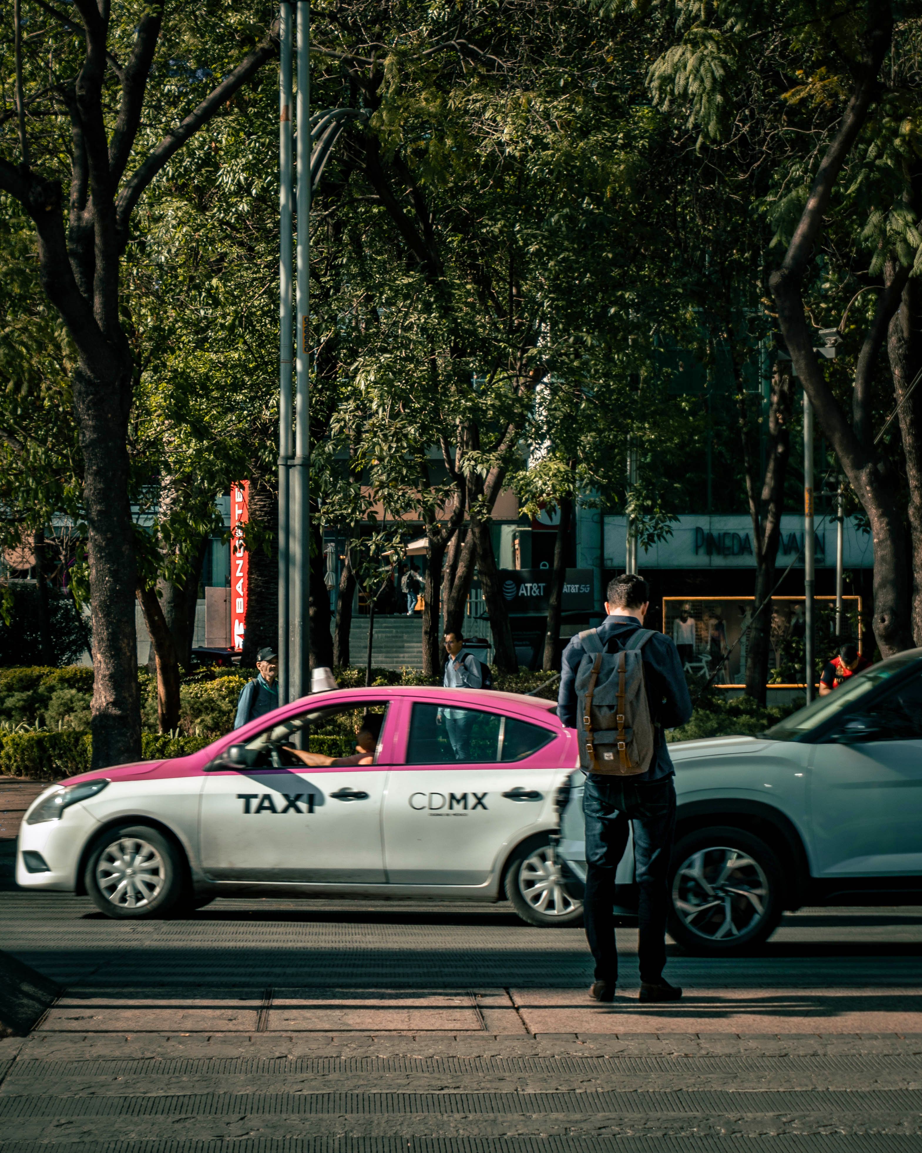 A bustling city street in Ciudad de México featuring a CDMX taxi and pedestrian.