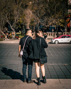 A couple walks on a sunny day in Mexico City, embodying urban romance and togetherness.