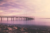 德国康斯坦茨码头，宁静的日落将柔和的粉色色调倒映在水面上