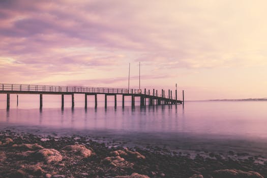 德国康斯坦茨码头，宁静的日落将柔和的粉色色调倒映在水面上