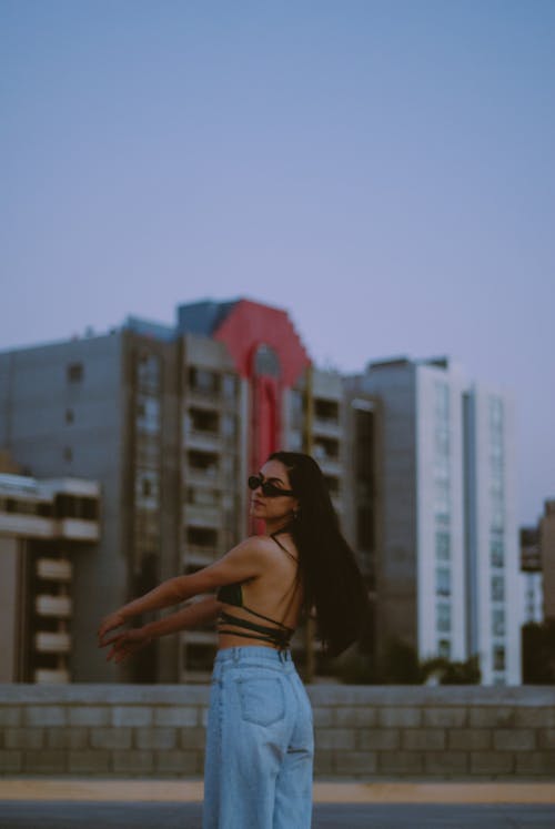 Back View of Woman with Long Hair Standing and Posing in Sunglassses