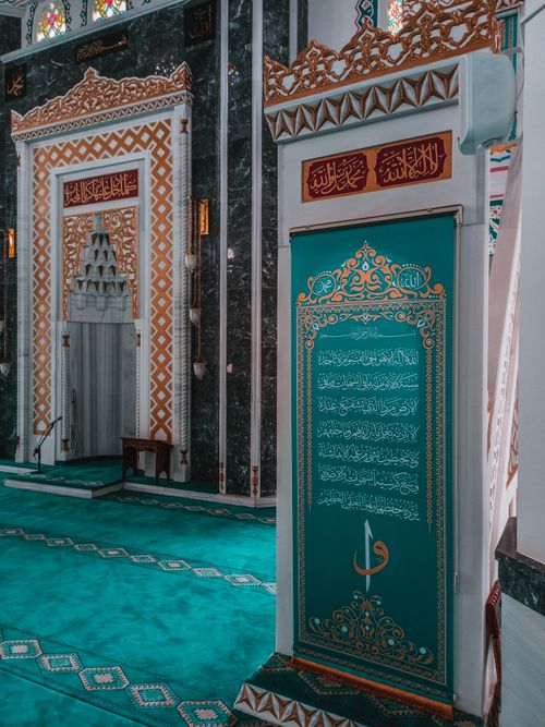 Free Explore the elegant and richly patterned interior of a mosque, showcasing stunning calligraphy and design. Stock Photo