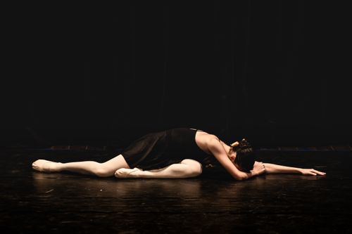 Free Ballerina gracefully poses on a stage, showcasing elegance and flexibility during a performance. Stock Photo