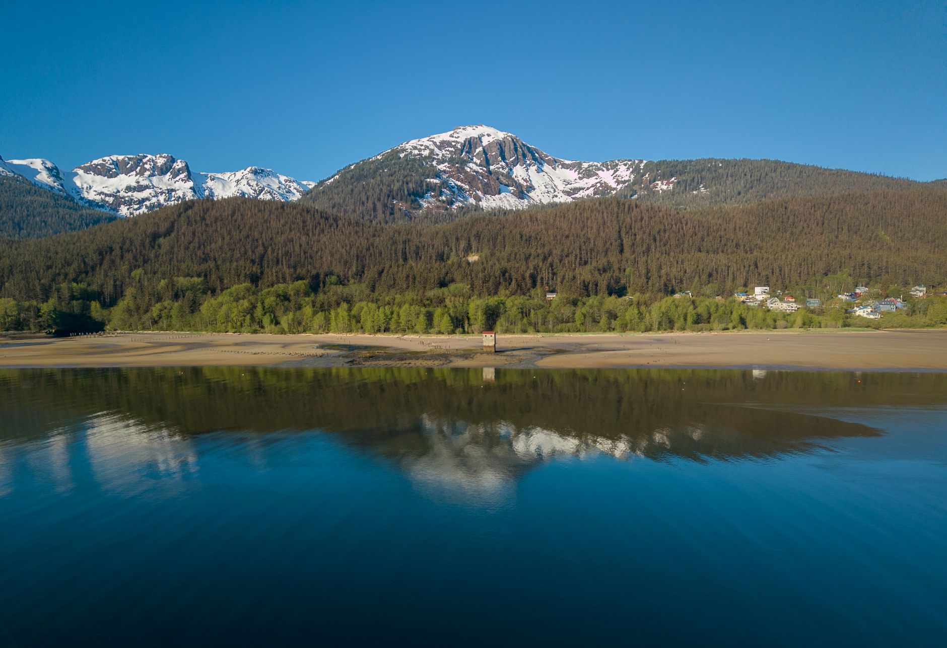 Breathtaking view of snow-capped mountains and serene lake reflections in Juneau, Alaska.