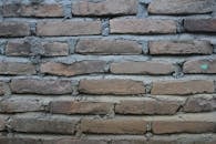 特写的风化砖墙展现出质朴的纹理，是理想的背景