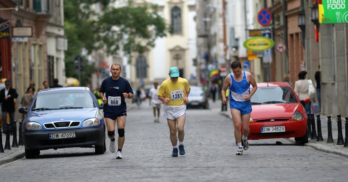 Three men running down a street in a race · Free Stock Photo