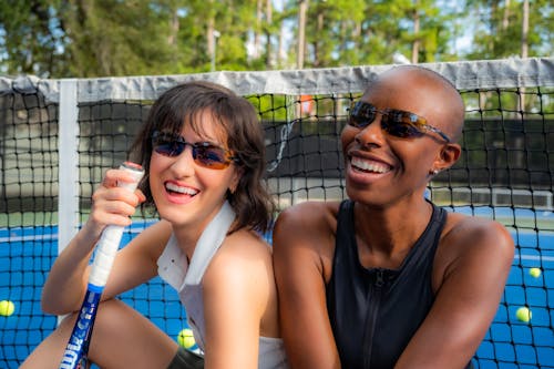 Smiling Women Sitting at Tennis Court