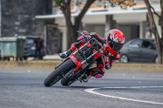 Motorcycle racer in vibrant gear takes a sharp turn on an urban track, showcasing speed and skill.