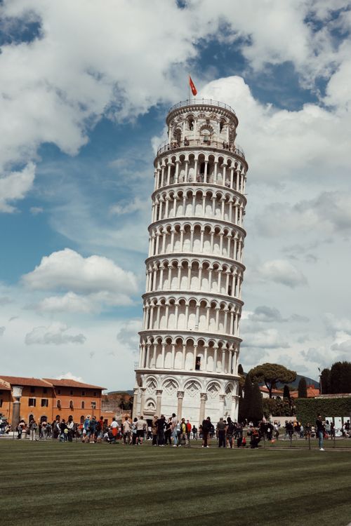 Free The renowned Leaning Tower of Pisa surrounded by tourists on a clear day, perfect for travel enthusiasts. Stock Photo