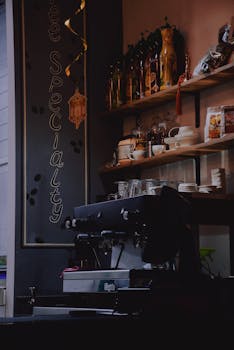 Warm and inviting café interior featuring shelves and coffee equipment, perfect for cozy gatherings.