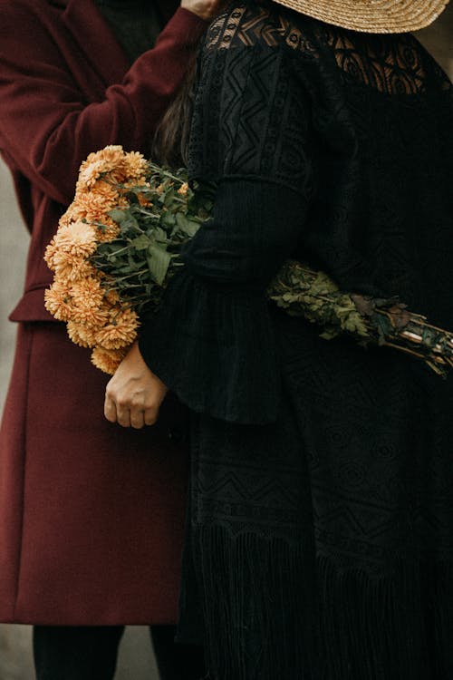 Two Fashionable Women Holding a Bouquet