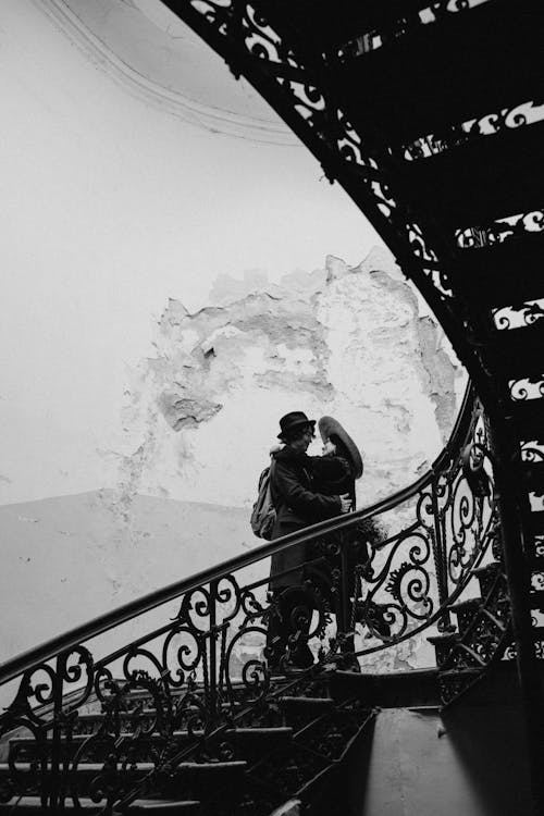 A Couple Standing on a Staircase and Hugging 