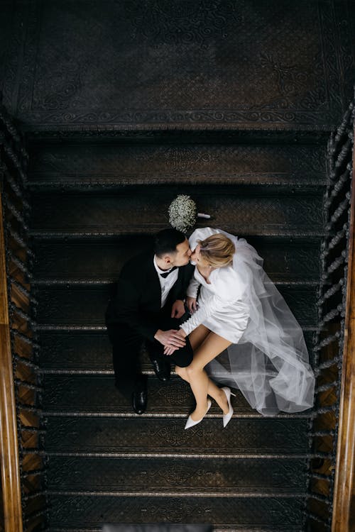 Newlyweds Sitting and Kissing on Stairs