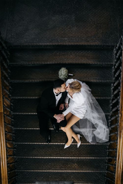Free Newlyweds embrace on elegant staircase, capturing love and elegance. Stock Photo