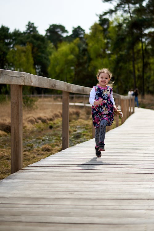Girl Running on Wooden Footpath