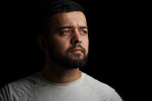 Studio Portrait of a Bearded Man in a White T-shirt Looking Away 