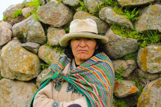 A Woman in a Colourful Shawl Posing Against Rocks