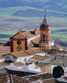 Aerial view of a colorful church and village rooftops in southern Spain.