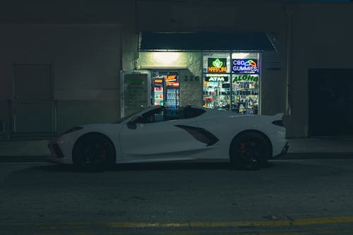 Sports Car Parked in Front of an Aloha Wellness Store at Night