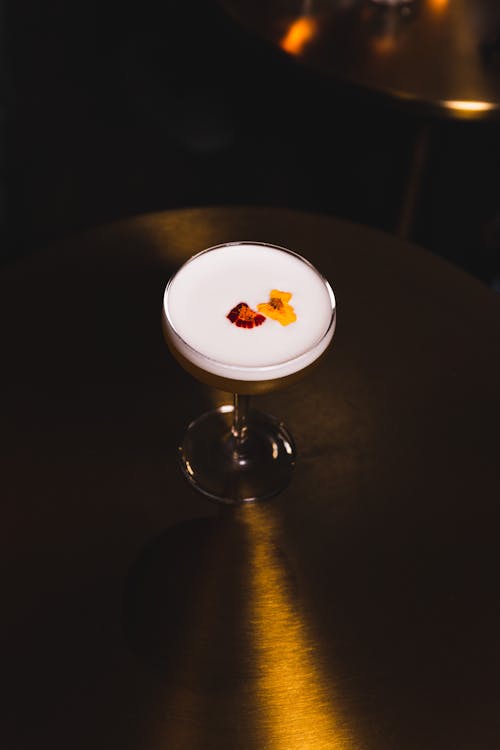 Glass of Cocktail on a Shiny Metal Table in a Dim Lit Room