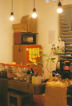 Cozy kitchen corner with jars, plants, and warm lighting, creating a rustic and inviting atmosphere.