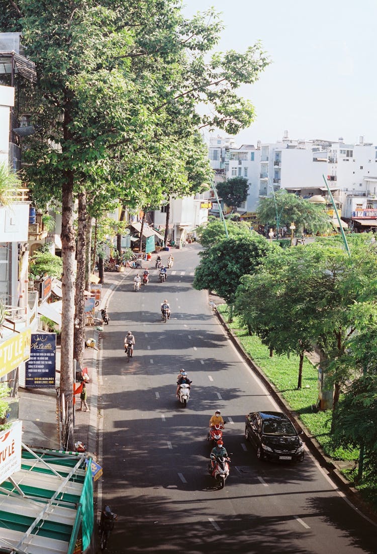 Summer City Street With Scooters, Bicycles, And A Car