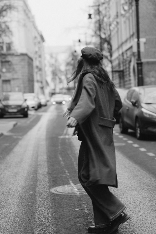 Free Black and white photo of a woman walking on a city street in winter. Stock Photo