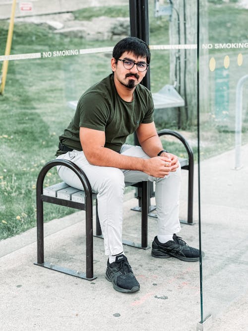 Young Man Wearing Eyeglasses Sitting on a Bench