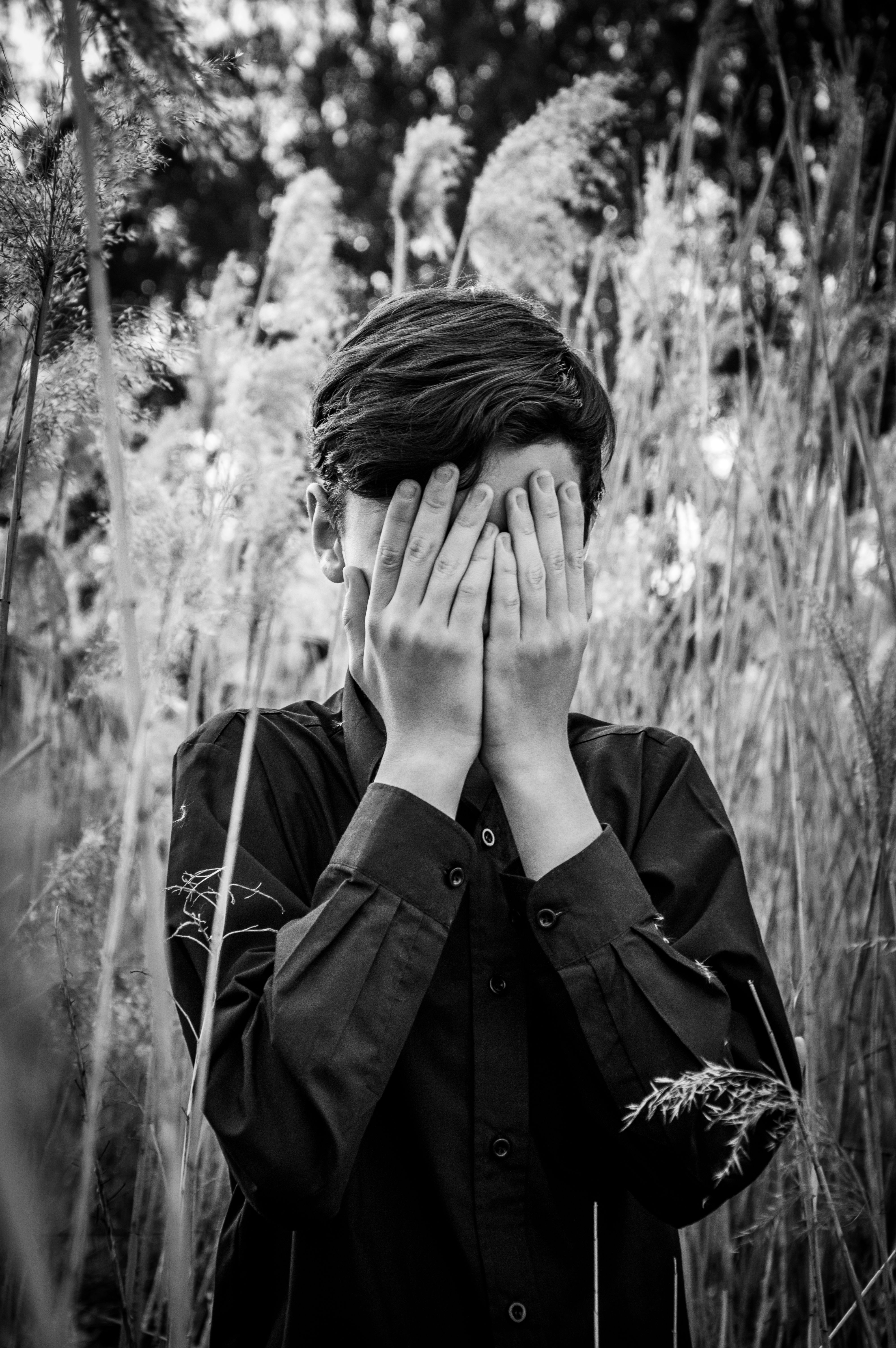 Black and White Photo of a Teenager Covering His Face with His Hands ...