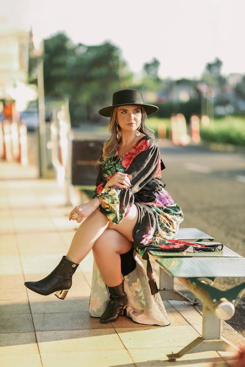 Confident Young Woman in a Hat Sitting on a Bench