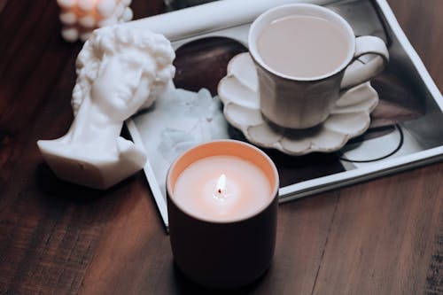 Wax Candle near Tray with Cup and Figurine