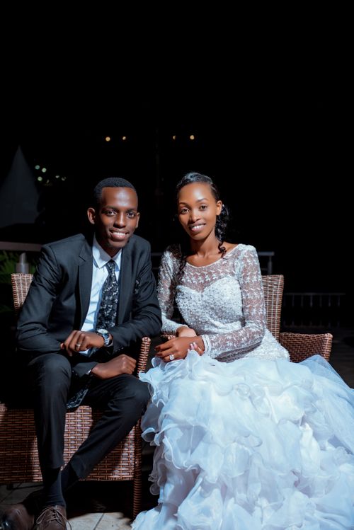Free A joyful couple in wedding attire posing against a black background Stock Photo